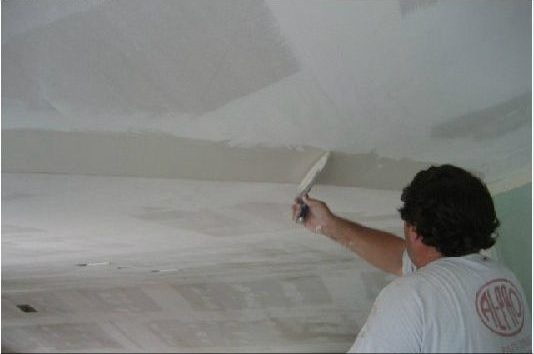 Al-Pro Ceilings guy applying knockdown texture to ceiling